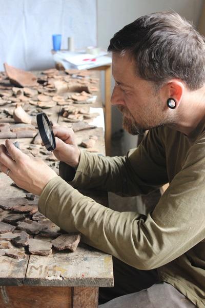 A Projects Abroad volunteer inspects artefacts on an archaeology placement in Peru Projects Abroad volunteer inspects ceramic artefacts on an archaeology placement in Peru