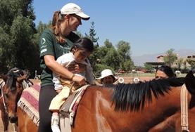 Volunteer Argentina An Equine Therapy volunteer in Argentina speaks to a child before starting a treatment session with her therapy horse.