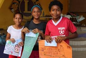 Volunteer Care Children pose with posters at a Care Project in Belize