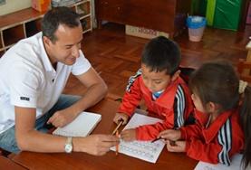Volunteer Peru A volunteer provides support for children as they finish their homework at one of our childcare placements at a school in Peru.