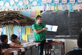 Volunteer Samoa A volunteer working with children reads an English book to her class in Samoa.
