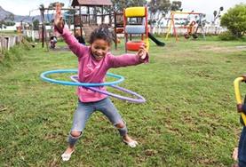 Volunteer South Africa A young child plays with hula hoops on a playground at our volunteer childcare placement in Cape Town, South Africa.