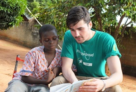 Volunteer Togo A childcare volunteer reads to a boy in Togo, working on his English literacy skills.