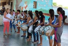 Volunteer Ecuador A Creative Arts volunteer working in Ecuador teaches a music lesson to local students using drums.