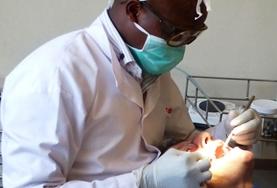 Volunteer Kenya A local dentist in Kenya performs a procedure on a patient as a Dentistry Elective intern observes and assists.