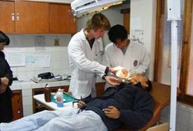 Volunteer Peru A Dentistry volunteer assists while a dentist examines a patient's teeth at a hospital in Peru.