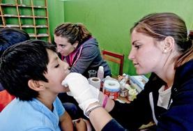 Volunteer Peru A Medicine intern examines a child during a medical outreach in Cusco, Peru.