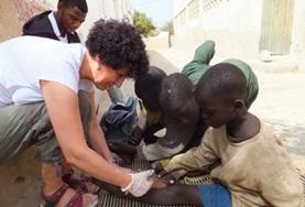 Volunteer Senegal A Nursing volunteer assists local medical staff with dressing children's wounds at our Medical placement in Senegal.