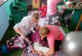 Volunteer Nepal Two Physiotherapy volunteers work together to treat a disabled child during their internship in Nepal.