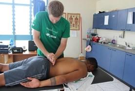 Volunteer Samoa A Physiotherapy intern treats a rugby player in Samoa who has injured himself during a match.