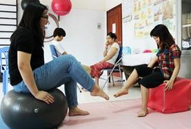 Volunteer Medicine & Healthcare A Medical volunteer works on strengthening a young girl's foot muscles at our Physiotherapy internship in Vietnam