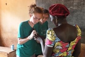 Volunteer Medicine & Healthcare A Public Health intern assesses a local woman's wound during a medical volunteer outreach in Togo.