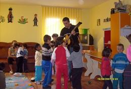 Volunteer Care A volunteer Art Therapist plays music for children at a placement in Romania