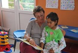 Volunteer Care A volunteer Social Worker reads to a child at a placement in Romania