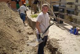 Volunteer South Africa A High School Special volunteer holds a shovel at a Building placement in South Africa