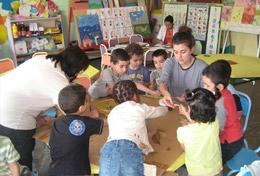 Volunteer Morocco A high school student volunteering in Morocco runs an educational activity with children, under the guidance of a local teacher.