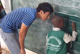Volunteer Senegal A high school student teaches a child how to write on a blackboard at his volunteer placement at a school in Senegal.