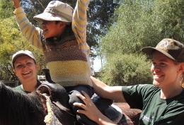 Volunteer Care A child reacts during a horse riding session with Equine Therapy volunteers