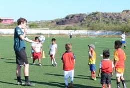 Volunteer Ecuador A Multi-sports volunteer prepares to throw a football to a team of children as part of a sports lesson in Ecuador.