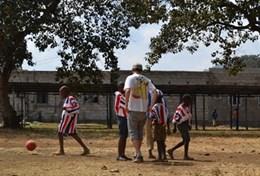 Volunteer Sports A volunteer coaches a group of students during a school sports lesson in Tanzania.