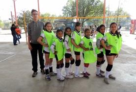 Volunteer Sports A Volleyball coaching volunteer poses with his team following a training session