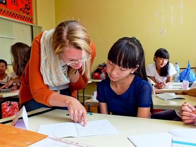 A Projects Abroad volunteer assists her student with her work at a school in Mongolia A volunteer helps her student with her school work in a classroom in Mongolia, Asia