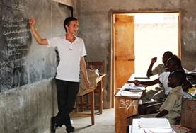 Volunteer Togo A Teaching volunteer demostrates a lesson on a blackboard to a class of school students in Togo.
