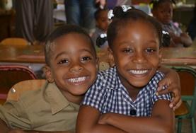 Volunteer Teaching Two children pose for a picture during a French class