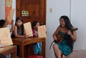 Volunteer Creative & Performing Arts A volunteer plays a musical instrument for a class of students
